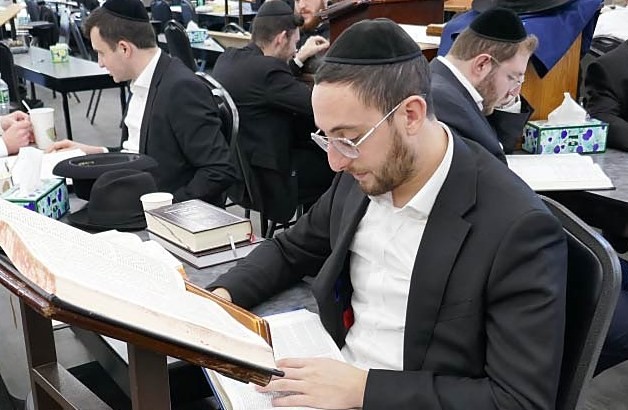 An avreich learning alone at his shtender in the beis medrash.